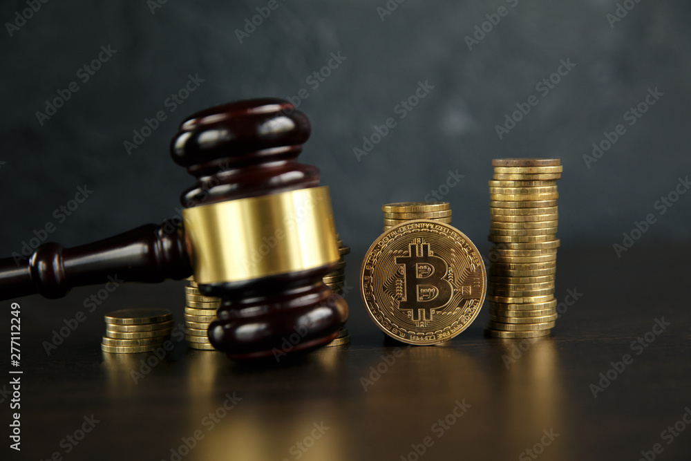 Auction gavel and bitcoin cryptocurrency money on a wooden desk, close-up. Law Gavel and golden bitcoin symbol on white background with copyspace