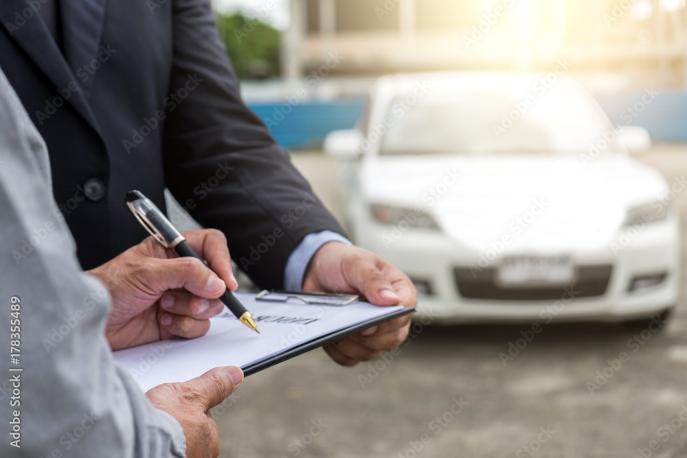 Insurance Agent examine Damaged Car and customer filing signature on Report Claim Form process after accident, Traffic Accident and insurance concept